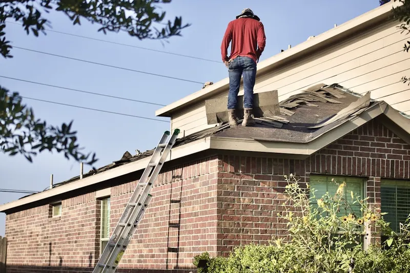 Professional roofer working on a residential roof in Grill